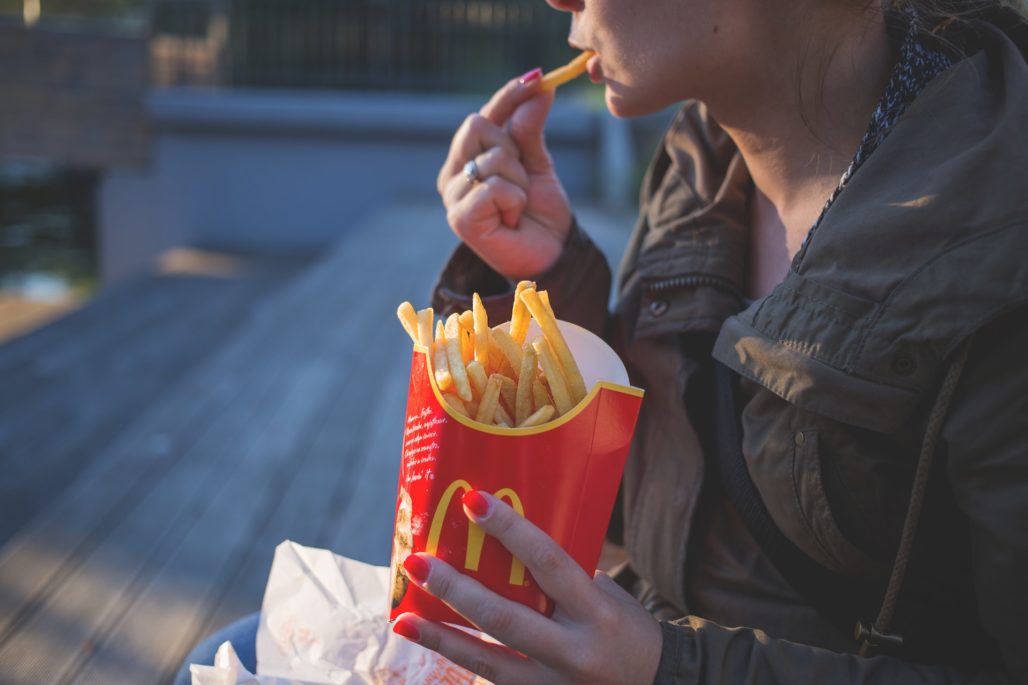 Woman eating Mcdonald's brand fries